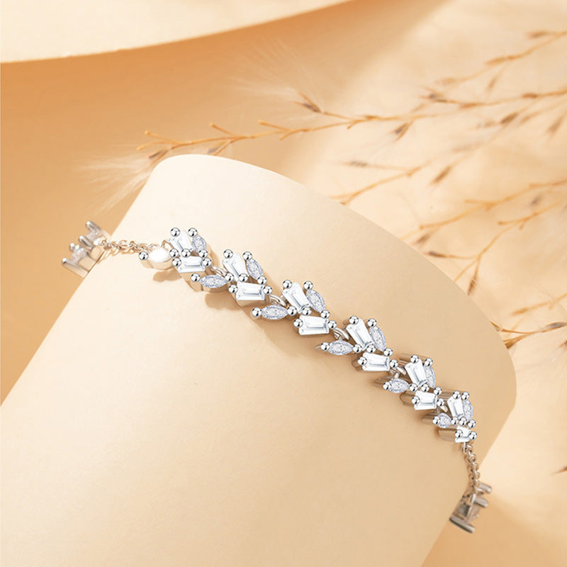 Silver bracelet with clear stones on a beige surface